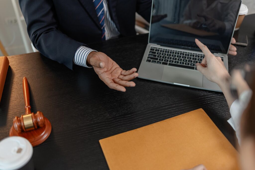 Legal Professional and Client Discussing Case over Laptop with Gavel